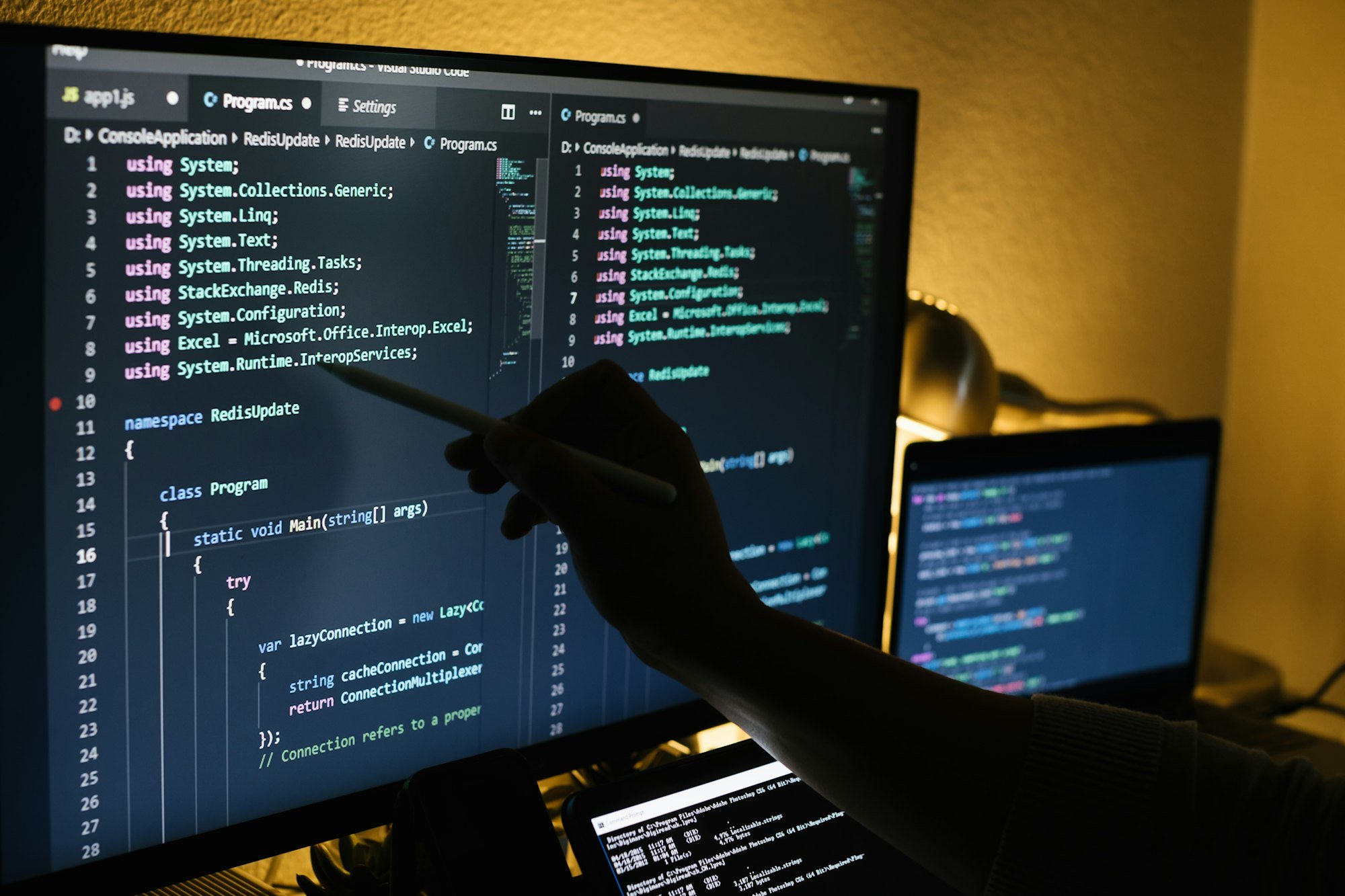 Man working at night coding and pointing on a screen with a pen Man working at night coding and pointing on a screen with a pen